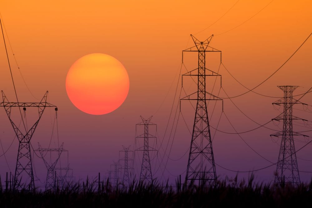 Sun setting behind electrical towers